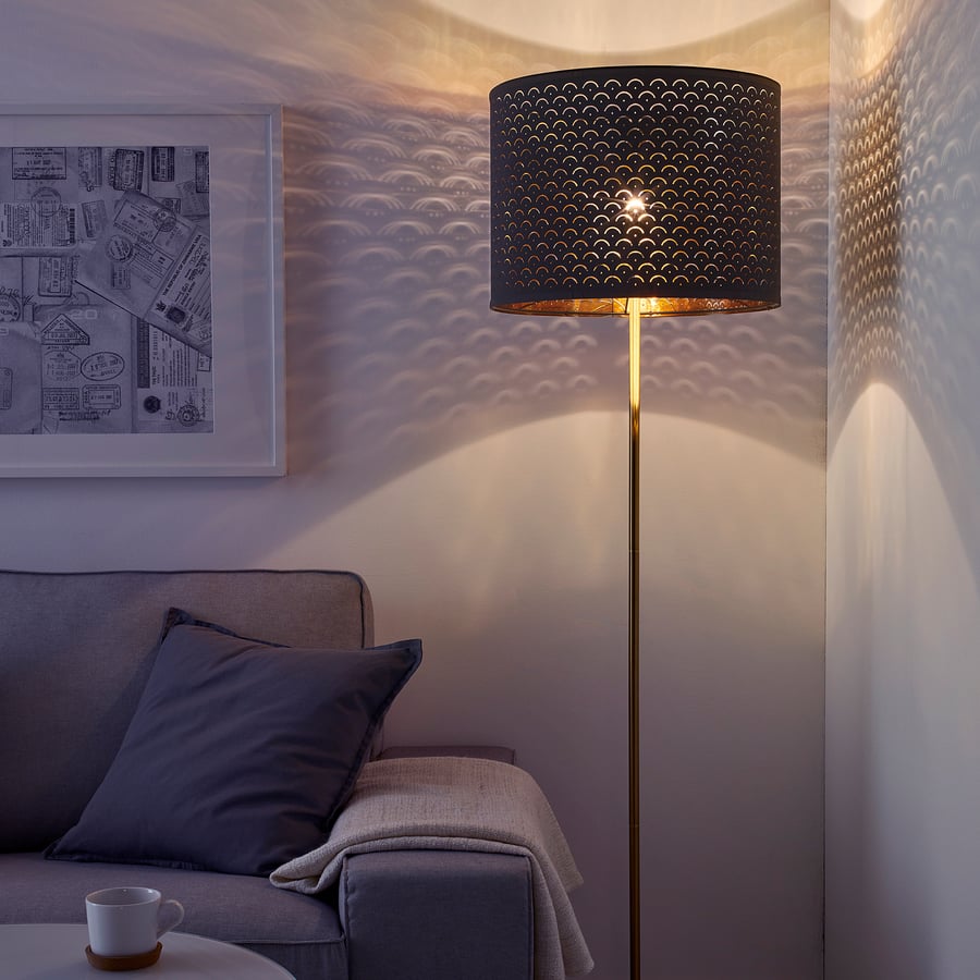 Floor lamp with textured black shade in a cozy living room setting.