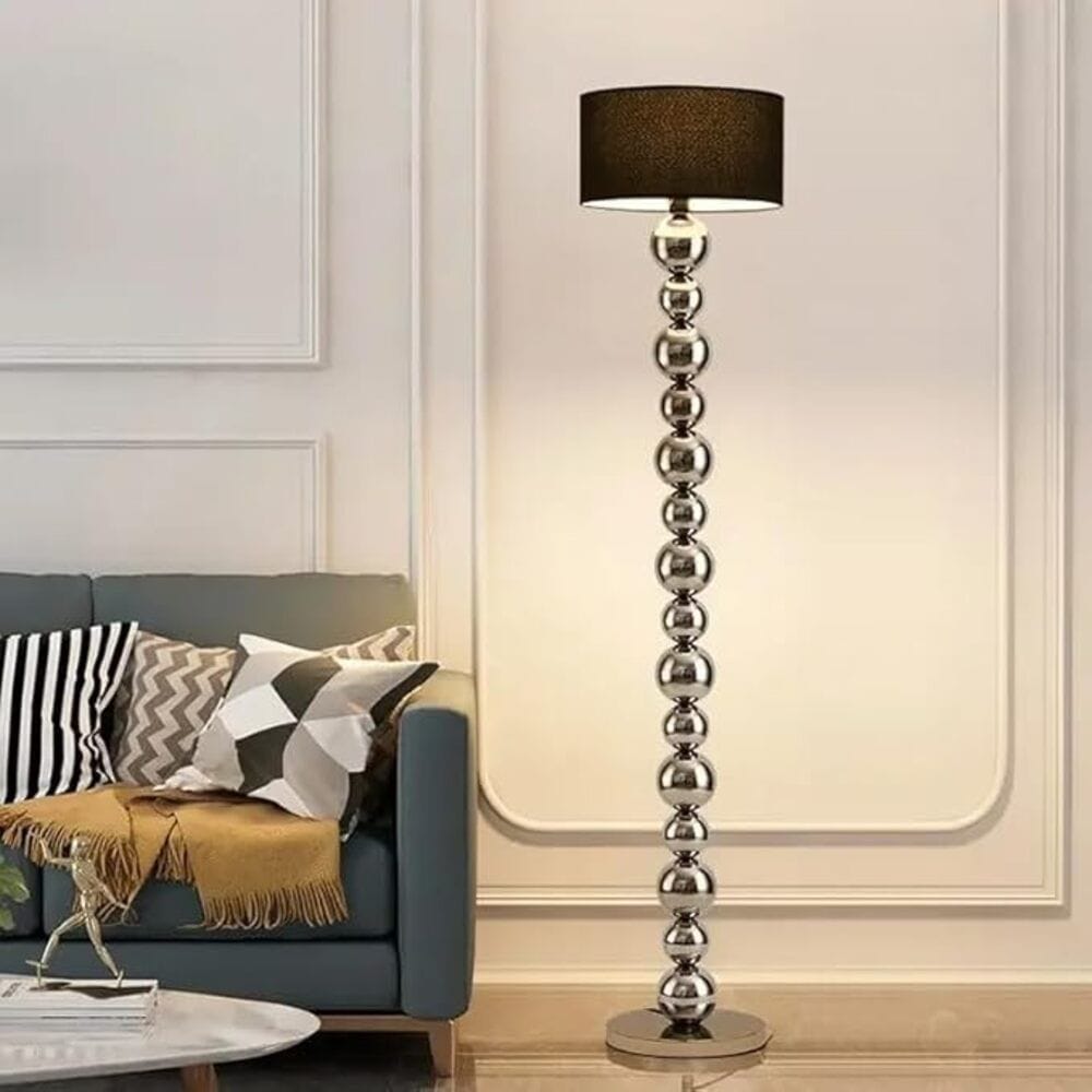 Decorative floor lamp with a black shade in a living room setting.