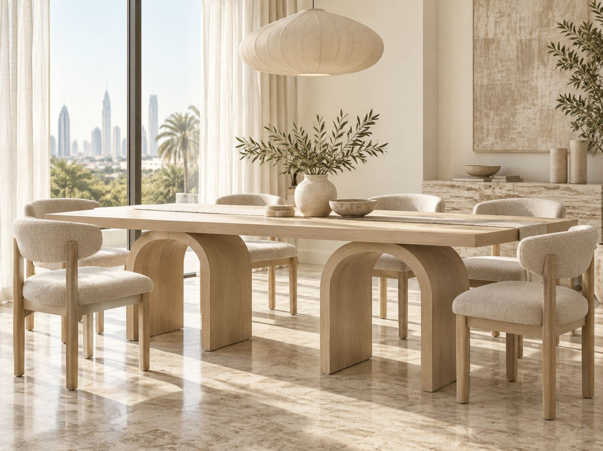 Light oak arch dining table in a bright Dubai villa dining room with boucle chairs