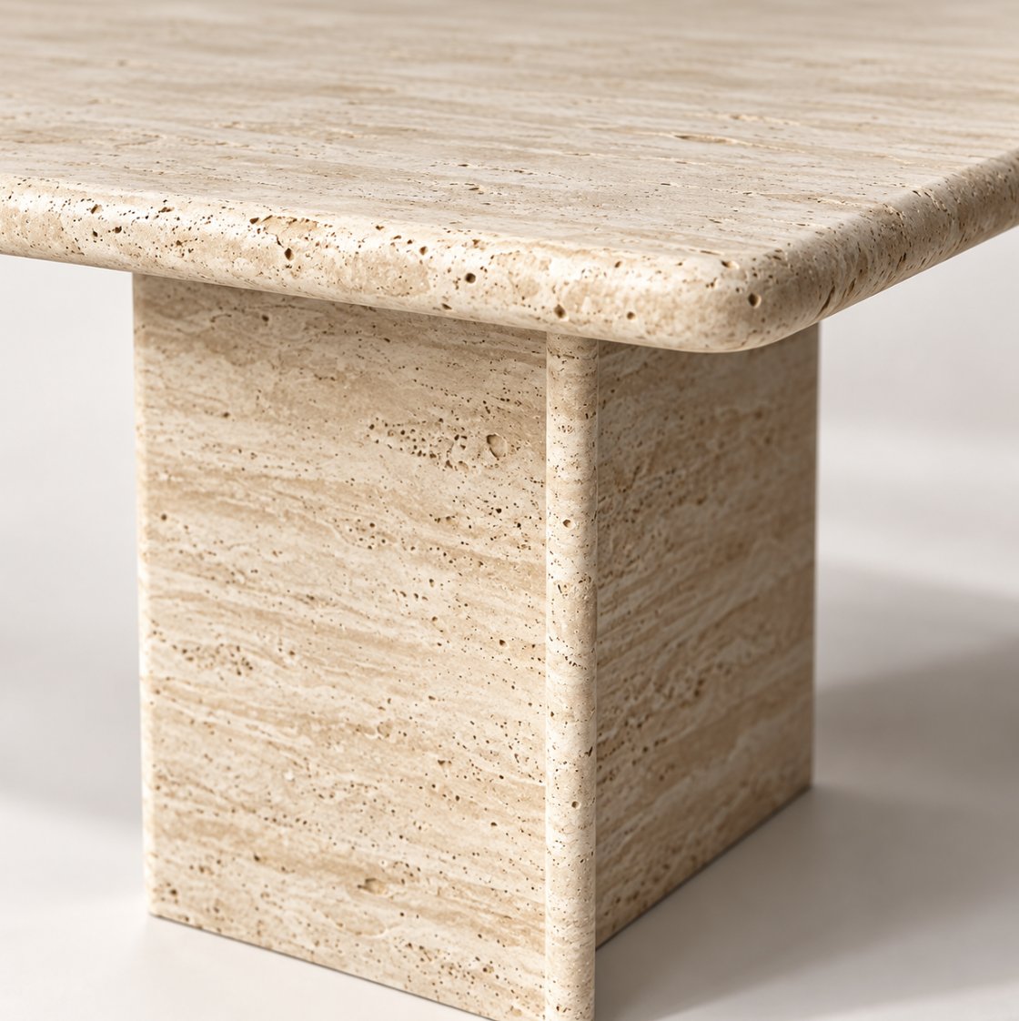 Close-up of travertine pores and rounded edge on the Terra dining table